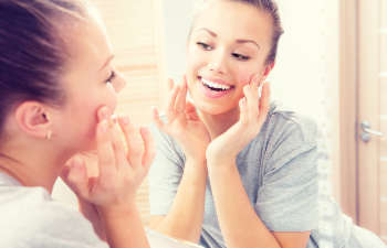 young woman checking her smile in a mirror