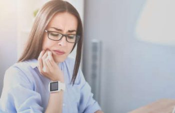 woman touching her mouth because of dental pains