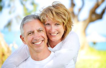 Jouful mature couple with perfect smiles enjoying a day outdoors.
